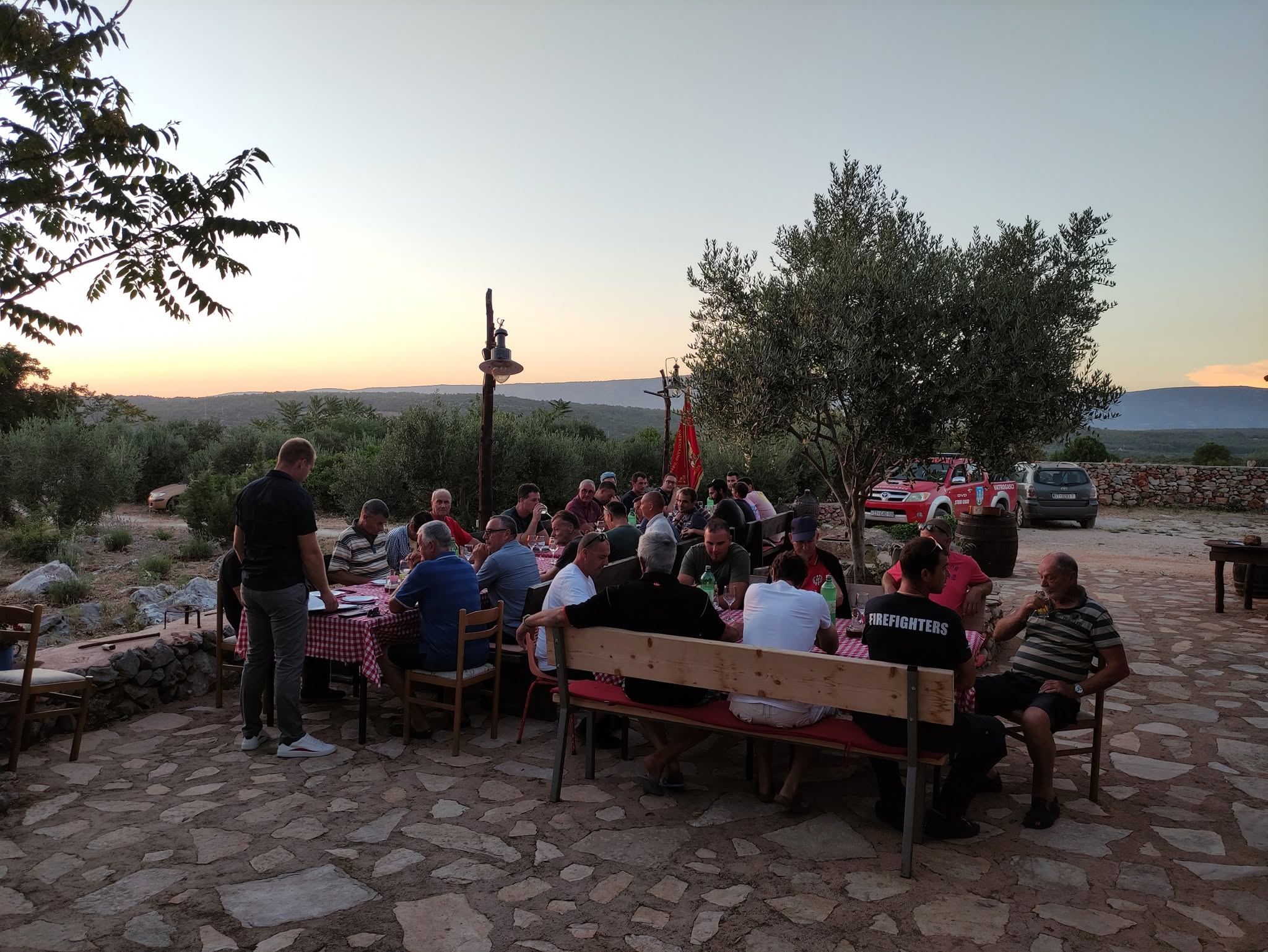 Članovi društva okupljeni za stolovima na otvorenom